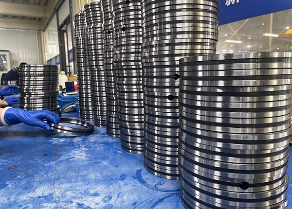 BY Bearings factory workers inspecting stacked crossed roller bearings for export order BY Bearings factory workers inspecting stacked crossed roller bearings for export order